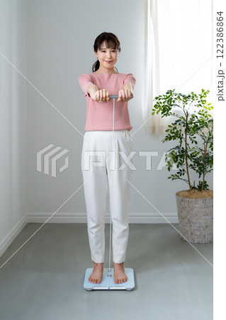 体重体組成計で測定する女性 122386864