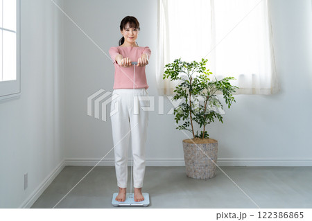 体重体組成計で測定する女性 体重体組成計で測定する女性 122386865