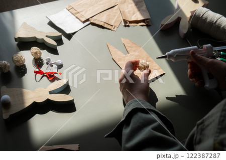 DIY process of woman making candid Easter present paper bag bunny arrangement decor. Series of handmade craft paper gift idea instruction manual activity for children. Zero waste eco-friendly 122387287