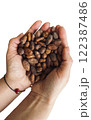 Isolated female hands holding a handful of cocoa beans. Table top view. 122387486