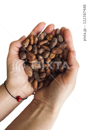 Isolated female hands holding a handful of cocoa beans. Table top view. 122387486
