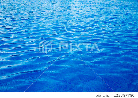 Water in swimming pool rippled water detail background. Blue in the water in the swimming pool. Water in swimming pool rippled water detail background. Blue in the water in the swimming pool. 122387780
