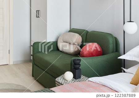 Stylish and Contemporary Green Couch Situated in a Modern and Chic Bedroom Design 122387889