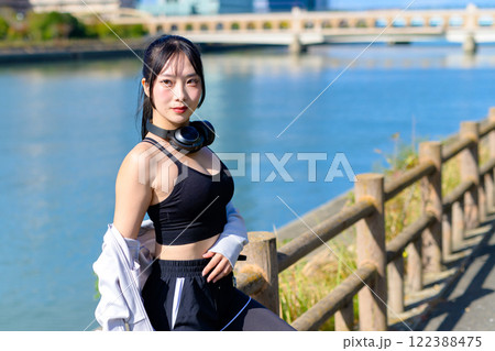 川沿いで歩く途中に座ってポーズをとるかっこいい女性 ポージング ダイエット 散歩 トリミングアップ 川沿いで歩く途中に座ってポーズをとるかっこいい女性 ポージング ダイエット 散歩 トリミングアップ 122388475