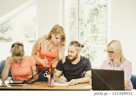 Students and teacher tutor in classroom Students and teacher tutor in classroom 122389452
