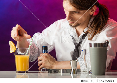 Barman at counter makes drink. Barman at counter makes drink. 122389934