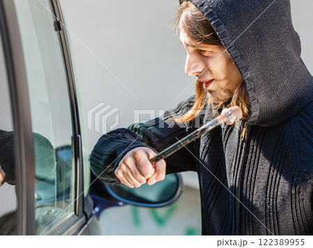 Thief burglar breaking smashing the car window 122389955