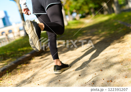秋の公園の街路樹の道をジョギングする若い女性の後ろ姿 ダイエット ボディメイク 下半身 秋の公園の街路樹の道をジョギングする若い女性の後ろ姿 ダイエット ボディメイク 下半身 122391207