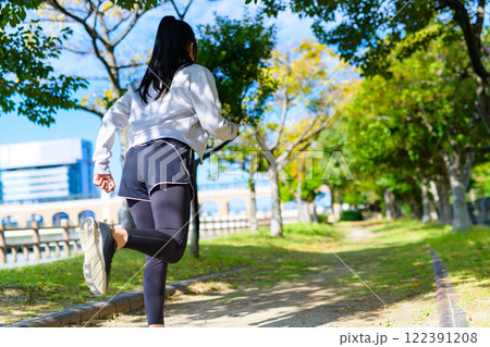 秋の公園の街路樹の道をジョギングする若い女性の後ろ姿 ダイエット ボディメイク 下半身 秋の公園の街路樹の道をジョギングする若い女性の後ろ姿 ダイエット ボディメイク 下半身 122391208
