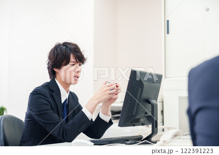 仕事中にルービックキューブをするビジネスマン 122391223