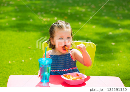 Toddler kid girl eating macaroni tomato pasta Toddler kid girl eating macaroni tomato pasta 122391580