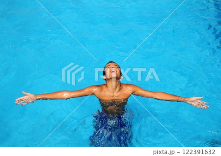 boy teenage relaxed open arms blue swimming pool 122391632