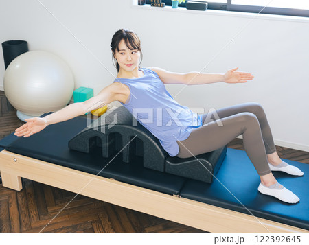 マシンピラティスのトレーニングをする女性 122392645