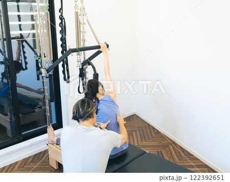 マシンピラティスのレッスンを受ける女性 マシンピラティスのレッスンを受ける女性 122392651