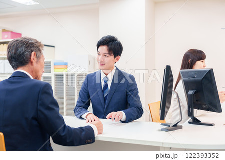 窓口で高齢者の来客の対応をする男性 窓口で高齢者の来客の対応をする男性 122393352
