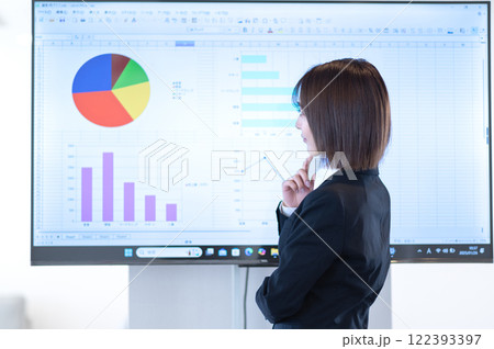 モニターに映る資料を見ながら考える若いビジネスウーマン 122393397