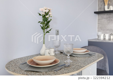 An Elegant and Modern Kitchen Table Setting Beautifully Decorated with Flowers and Glassware 122394212