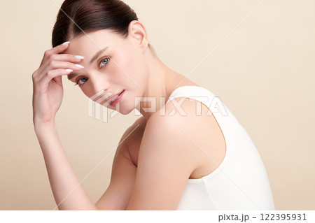 Beautiful young woman with clean fresh skin on beige background, Face care, Facial treatment, Cosmetology, beauty and spa, women portrait. Beautiful young woman with clean fresh skin on beige background, Face care, Facial treatment, Cosmetology, beauty and spa, women portrait. 122395931