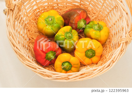 Variety peppers in a straw basket. Orange and red ripe vegetables in supermarket. Top view. Variety peppers in a straw basket. Orange and red ripe vegetables in supermarket. Top view. 122395963