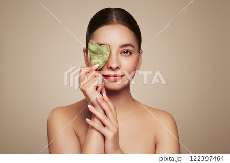 Young woman doing scrapping massage facial skin Young woman doing scrapping massage facial skin 122397464