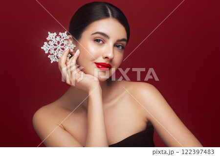 Beautiful young woman with glowing snowflake Beautiful young woman with glowing snowflake 122397483