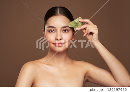 Young woman doing scrapping massage facial skin 122397486
