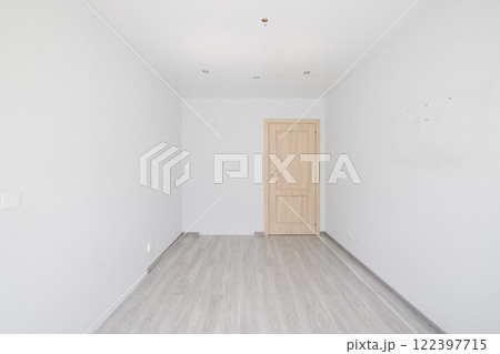 A minimalist empty room features a wooden door along with stylish grey flooring design 122397715