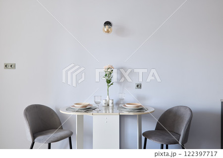 A modern minimalist dining table set featuring a charming floral centerpiece for decor 122397717
