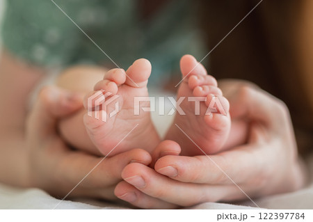 Happy family. Tiny newborn infant male or female baby feet on mother hands. Mother holding newborn child. Mom and her baby. Maternity tenderness parenthood new life concept. Handle with care 122397784