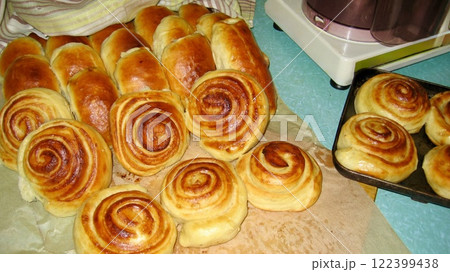 Freshly baked round buns with a golden crust on kraft paper. The warm, appetizing look of the bread evokes a cozy, homemade atmosphere. Freshly baked round buns with a golden crust on kraft paper. The warm, appetizing look of the bread evokes a cozy, homemade atmosphere. 122399438