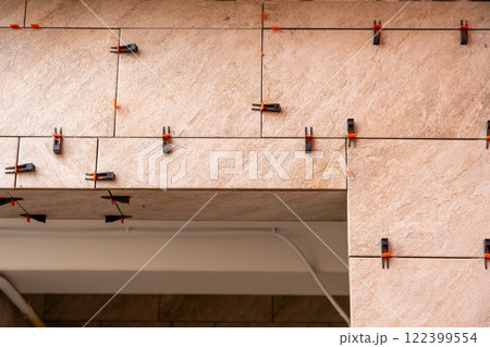 Tile leveling system with plastic clips and wedges, shot while the tile mortar sets. 122399554
