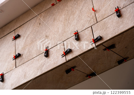Tile leveling system with plastic clips and wedges, shot while the tile mortar sets. Tile leveling system with plastic clips and wedges, shot while the tile mortar sets. 122399555
