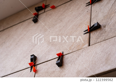 Tile leveling system with plastic clips and wedges, shot while the tile mortar sets. Tile leveling system with plastic clips and wedges, shot while the tile mortar sets. 122399562