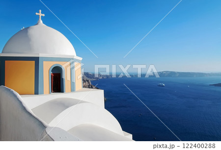 Volcano caldera and Aegean Sea with the white and blue old church on the mountainside in the foreground. Thira, Santorini island, Greece. 122400288