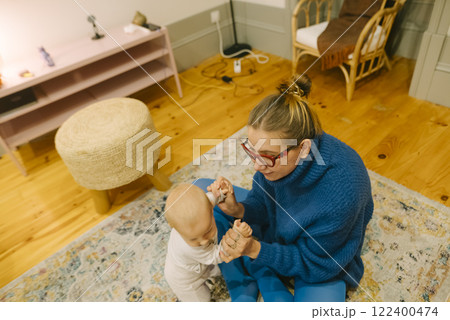 A Heartwarming Engaging Moment Between Caregiver and Baby in a Cozy, Loving Space A Heartwarming Engaging Moment Between Caregiver and Baby in a Cozy, Loving Space 122400474