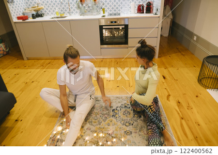 A Couple Engaged in Yoga Practice Together in Their Stylish, Modern Kitchen Environment A Couple Engaged in Yoga Practice Together in Their Stylish, Modern Kitchen Environment 122400562