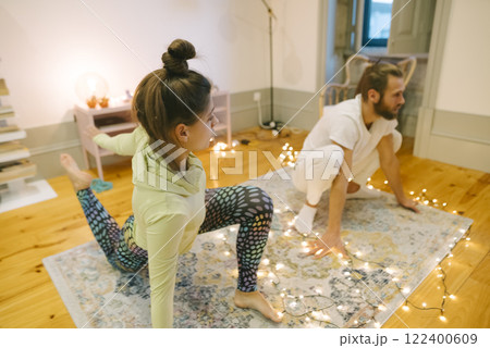 Yoga Partners Engaging in a Relaxed and Cozy Practice Together in a Comfortable Setting Yoga Partners Engaging in a Relaxed and Cozy Practice Together in a Comfortable Setting 122400609