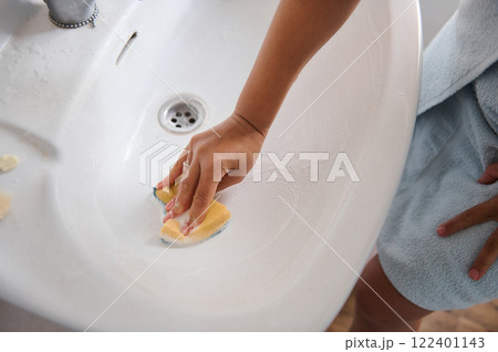 Hand Cleaning a Ceramic Sink Basin with a Sponge at Home Hand Cleaning a Ceramic Sink Basin with a Sponge at Home 122401143