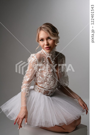 Elegant woman in lingerie and tulle poses gracefully in studio setting 122401543