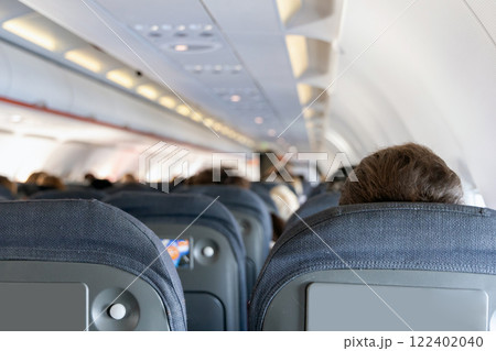 Inside the passenger plane cabin with people. 122402040