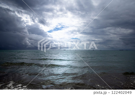 Beautiful dark evening sea and sky with dark clouds through which light passes. Beautiful dark evening sea and sky with dark clouds through which light passes. 122402049