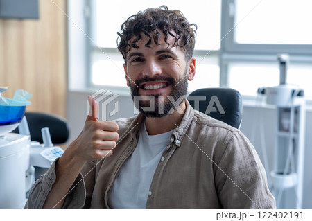 Man smiling to camera sitting in dental chair showing like gesture Man smiling to camera sitting in dental chair showing like gesture 122402191