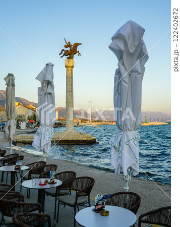 Adriatic Riviera, Kastel Stari waterfront promenade with cafe tables, monument with a horseman Adriatic Riviera, Kastel Stari waterfront promenade with cafe tables, monument with a horseman 122402672