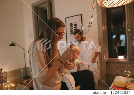 A Cozy Family Moment with Their Baby During a Peaceful Night Time at Home Together A Cozy Family Moment with Their Baby During a Peaceful Night Time at Home Together 122402824