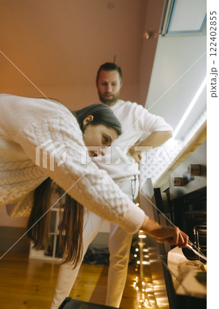 A Candid Moment Depicting Two Individuals as They Prepare a Cozy Atmosphere Together 122402855