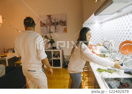 A couple washes dishes together in their modern kitchen, promoting teamwork and unity 122402879