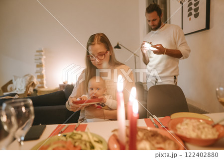 A Cozy Family Dinner with Soft Candlelight, Delicious Food, and a Happy Baby Present 122402880