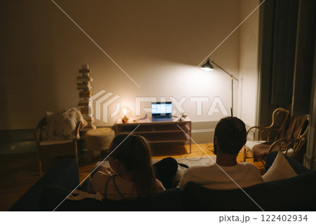 Enjoying a Cozy Night In Watching Movies and Shows Together in a Comfortable Living Room 122402934
