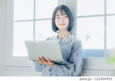 部屋でパソコンを使う若い女性 122404453