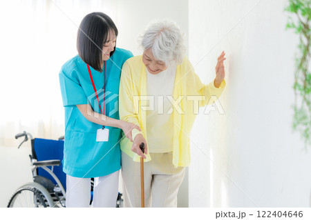リハビリ 介護施設で働く若い女性とシニア女性 リハビリ 介護施設で働く若い女性とシニア女性 122404646